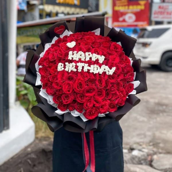 Buket mawar merah dengan tulisan Happy Birthday dari bunga putih