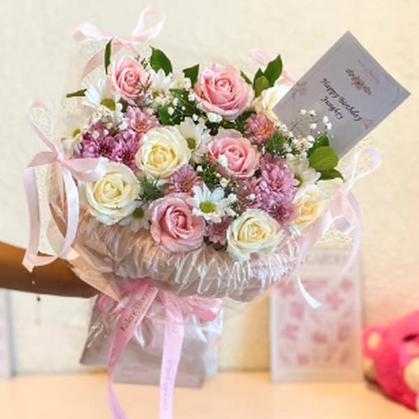 Buket mawar pink dan putih dengan kartu ucapan dan pita pink